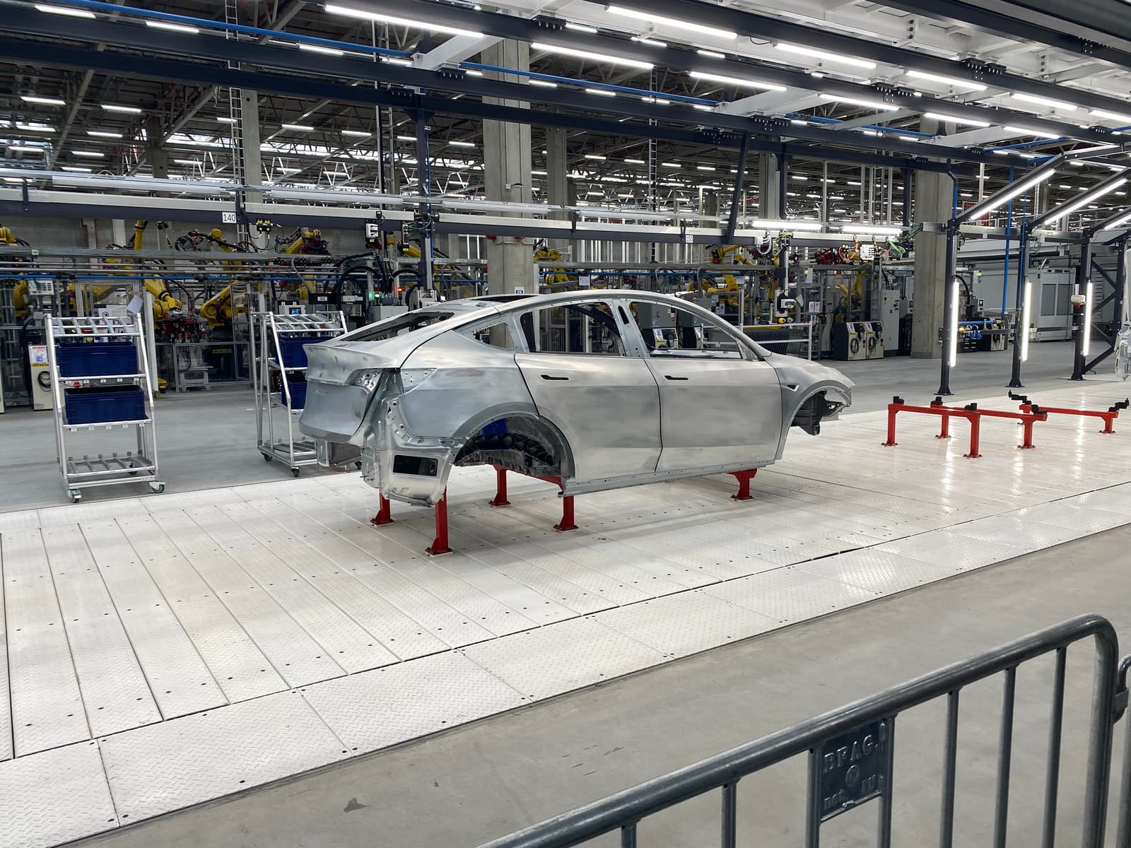 Rohkarosserie eines Model Y auf roten Böcken in der Karosseriefertigung der Gigafactory Berlin-Brandenburg