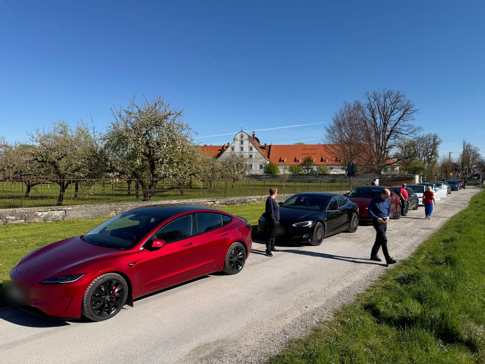 Roter Model 3 auf einer Landstraße vor einem Gehöft