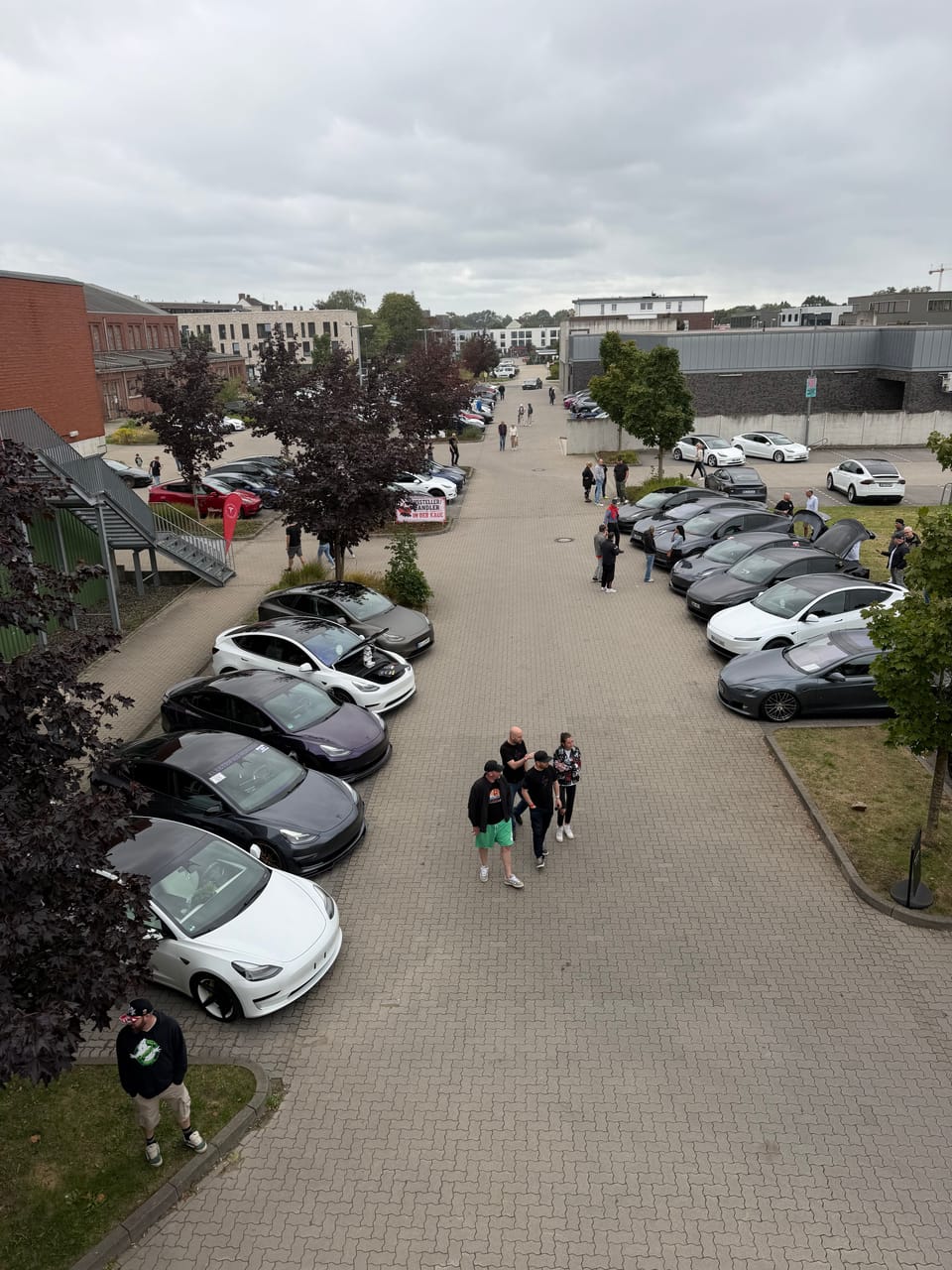 Die Allee von erhöhtem Standpunkt, Besucher zwischen den Fahrzeugen