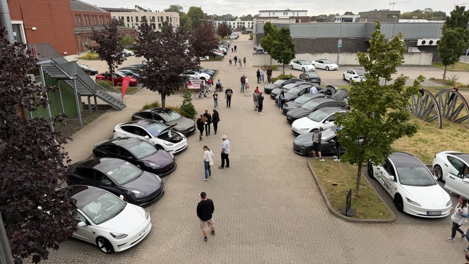 Besucher gehen zwischen den ausgestellten Fahrzeugen die Allee entlang
