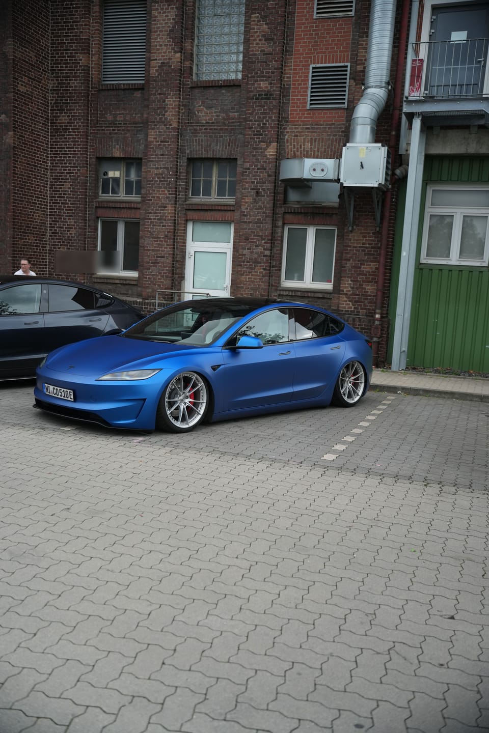 Mattblauer Model 3 mit Tieferlegung und Sonderfelgen in der Seitenansicht