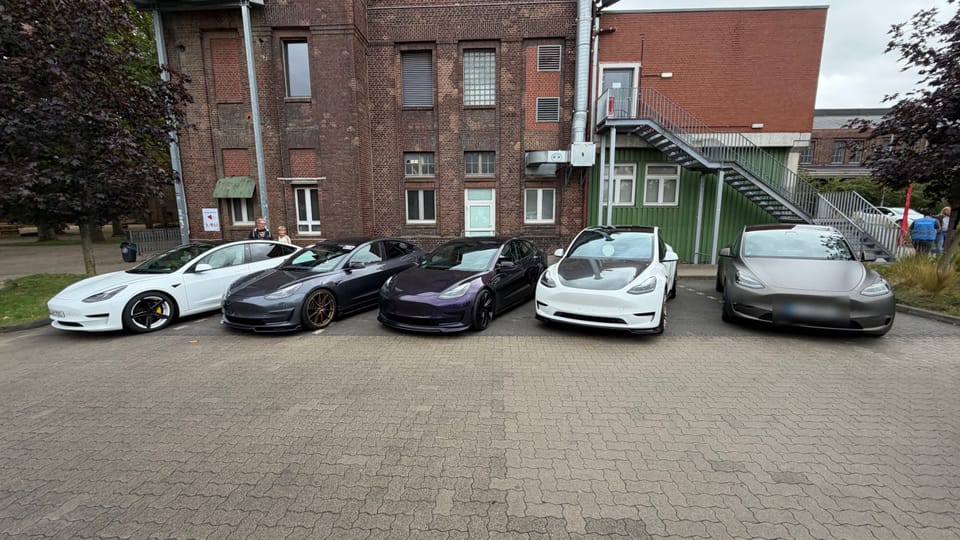 Fünf Teslas vor dem grün gestrichenen Tor des Zechengebäudes