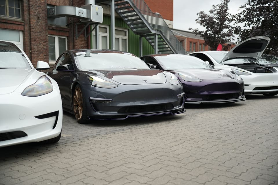 Mehrere Teslas mit geöffneten Türen nebeneinander vor der Zeche