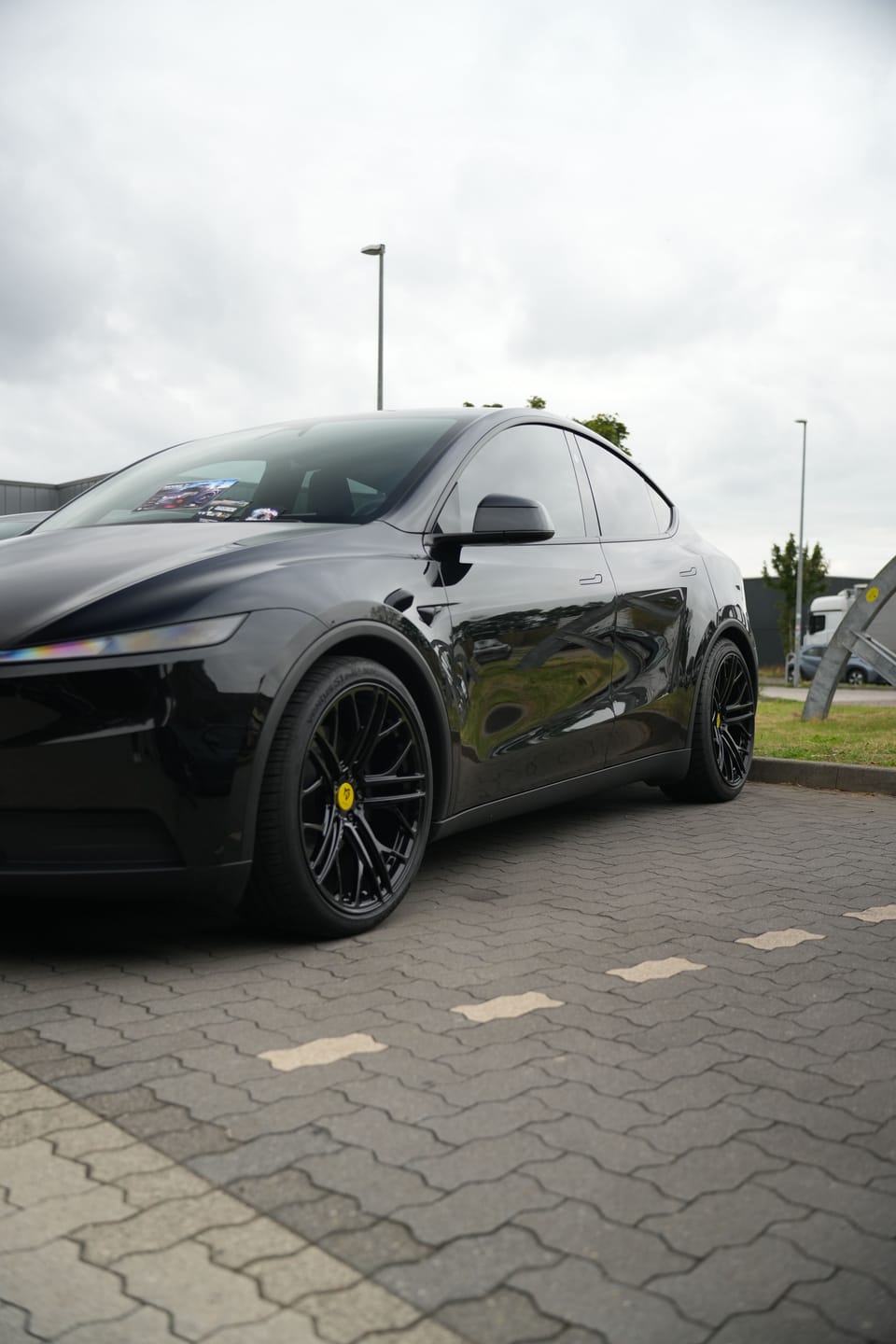 Schwarzer Tesla einzeln auf dem gepflasterten Vorplatz