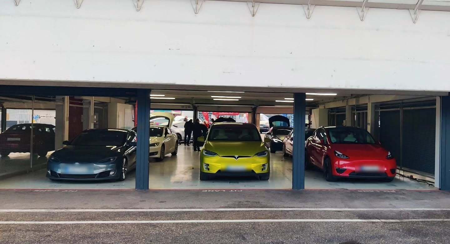 Drei Teslas in den Boxen am Hockenheimring: ein Model S, ein gelbes Model X und ein rotes Model Y