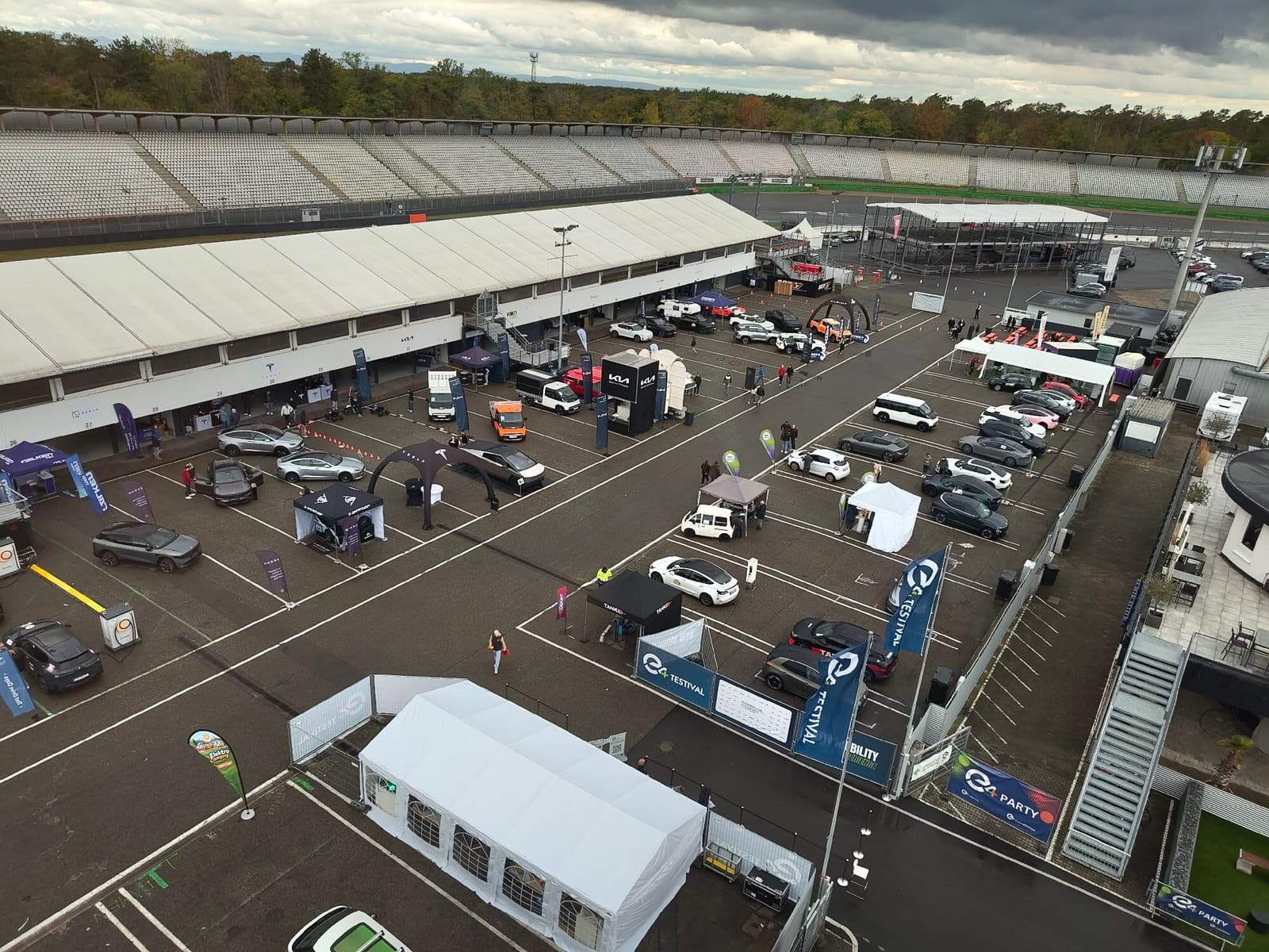 Blick von oben auf das Fahrerlager des Hockenheimrings beim e4 TESTIVAL mit Zelten, Ständen und Elektroautos