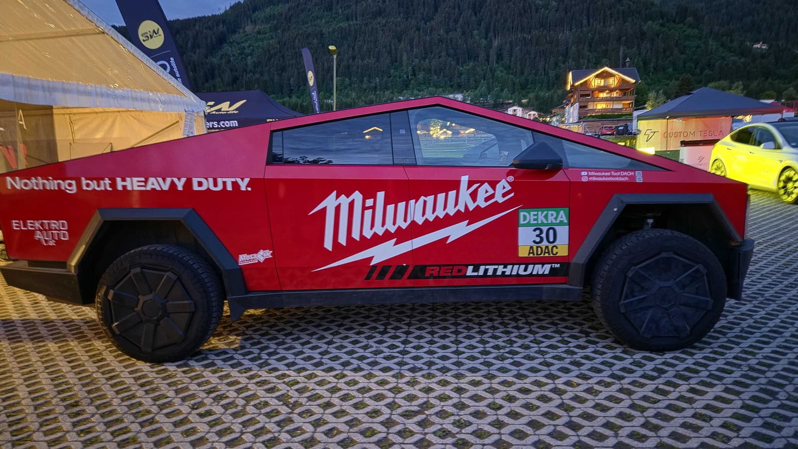 Rot folierter Cybertruck mit Milwaukee-Beschriftung am Abend auf dem Veranstaltungsgelände