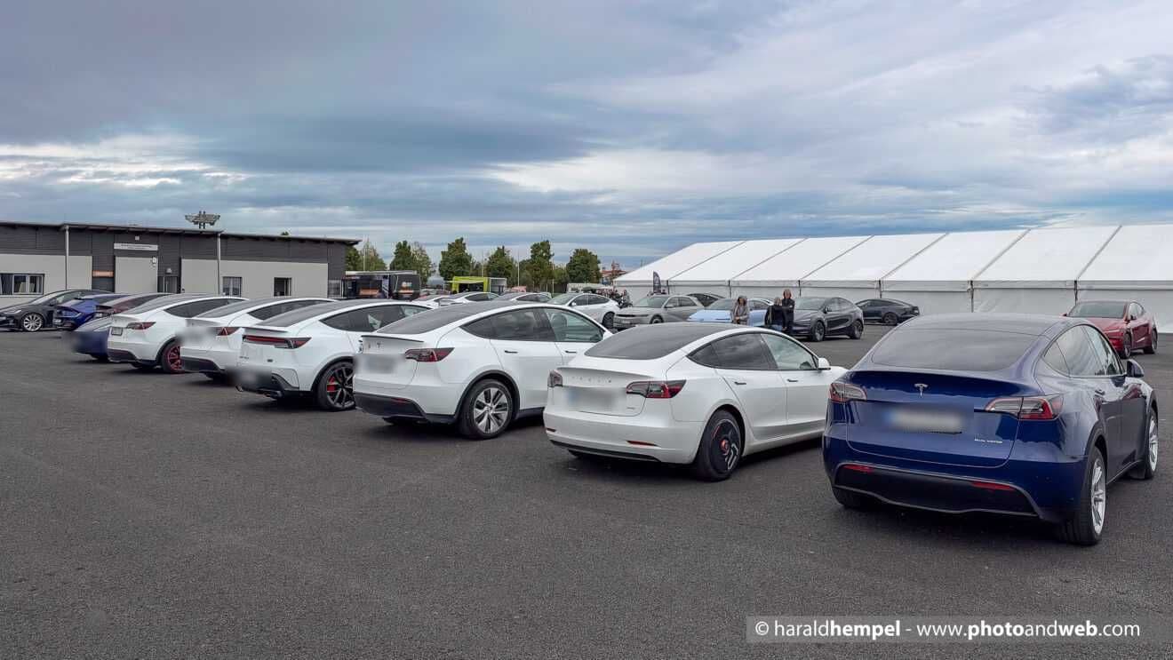 Reihen von Teslas auf dem Ausstellerparkplatz vor dem großen Messezelt
