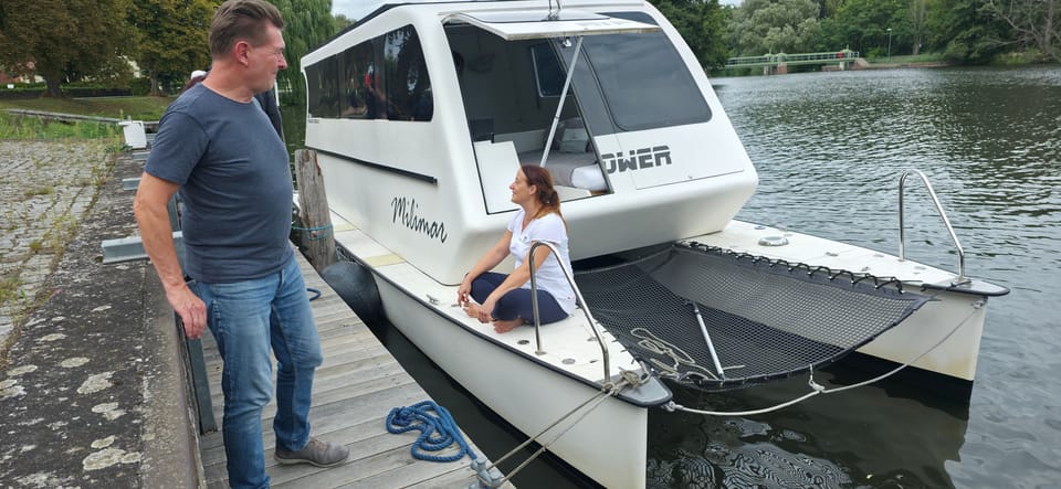 Zwei Personen am Steg neben dem Katamaran