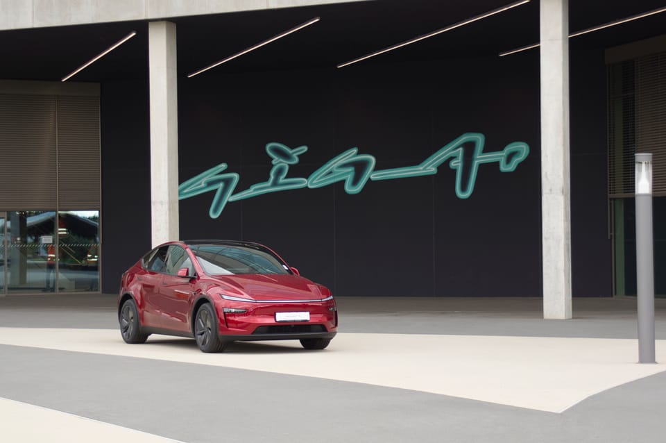Roter Model Y in der Halle vor dem leuchtenden Giga-Schriftzug