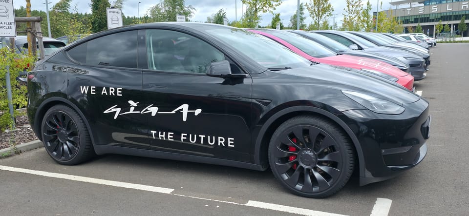 Schwarzer Model Y mit Giga-Schriftzug auf dem Parkplatz