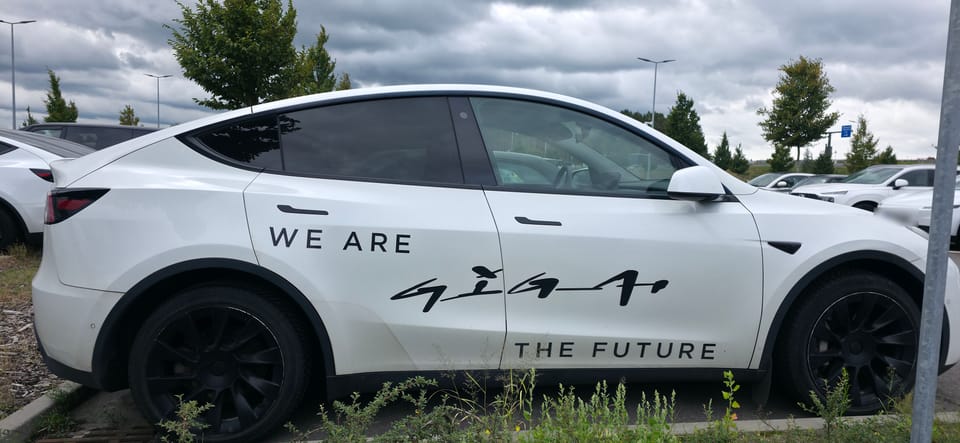 Weißer Model Y mit der Aufschrift „We are Giga, the future"