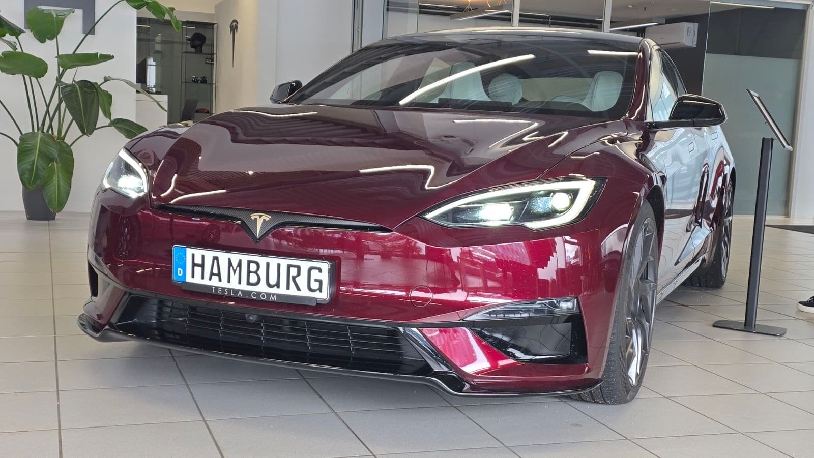 Weinroter Tesla Model S Signature von vorne im Ausstellungsraum