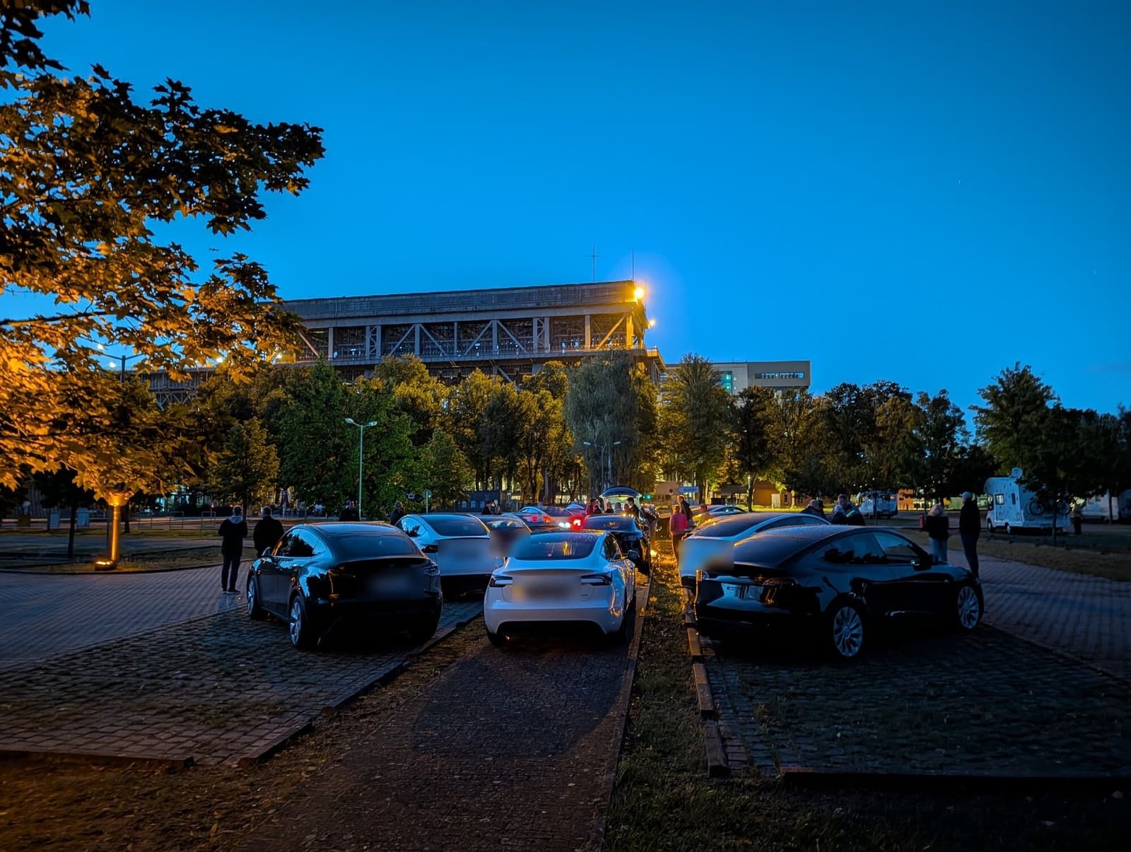 Die Fahrzeuge in der Abenddämmerung auf dem Parkplatz, im Hintergrund das alte Hebewerk