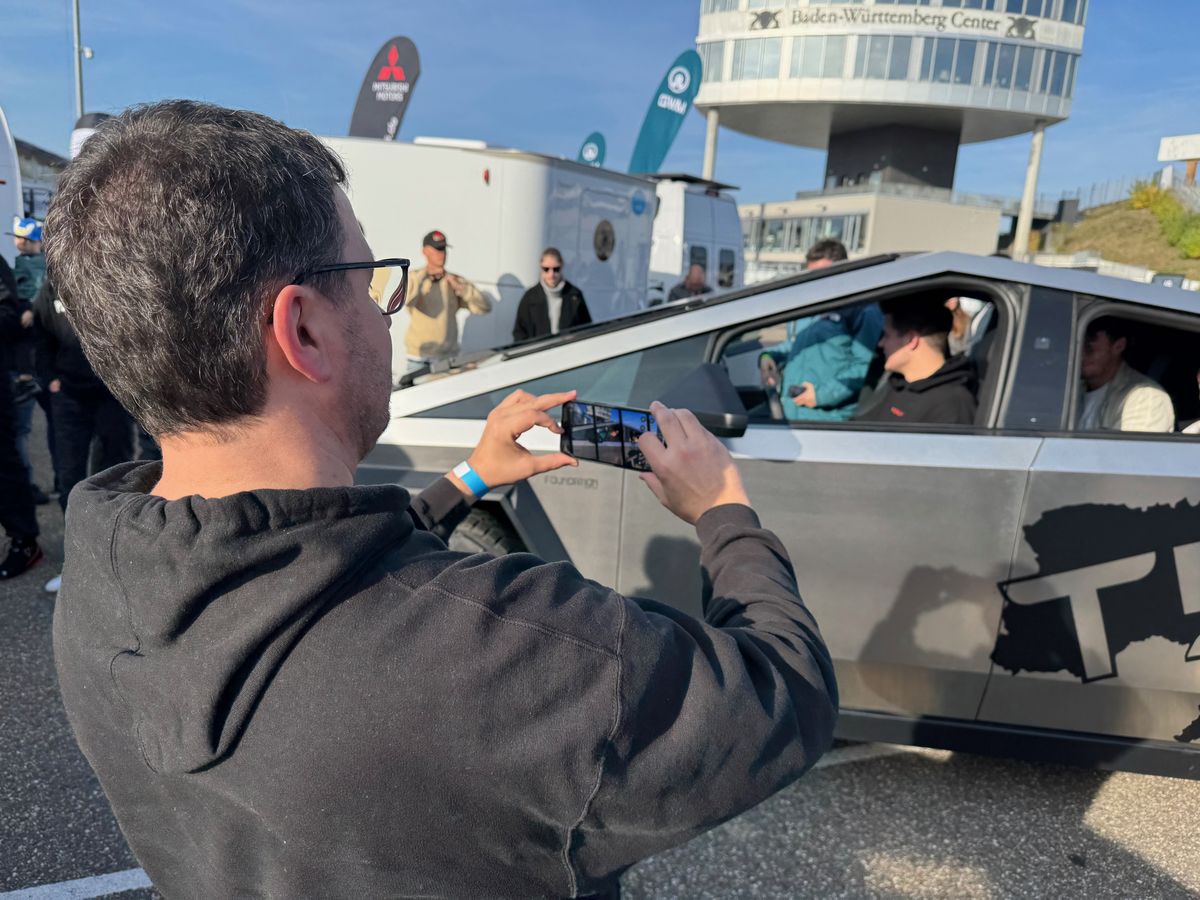Besucher fotografiert einen Cybertruck im Fahrerlager