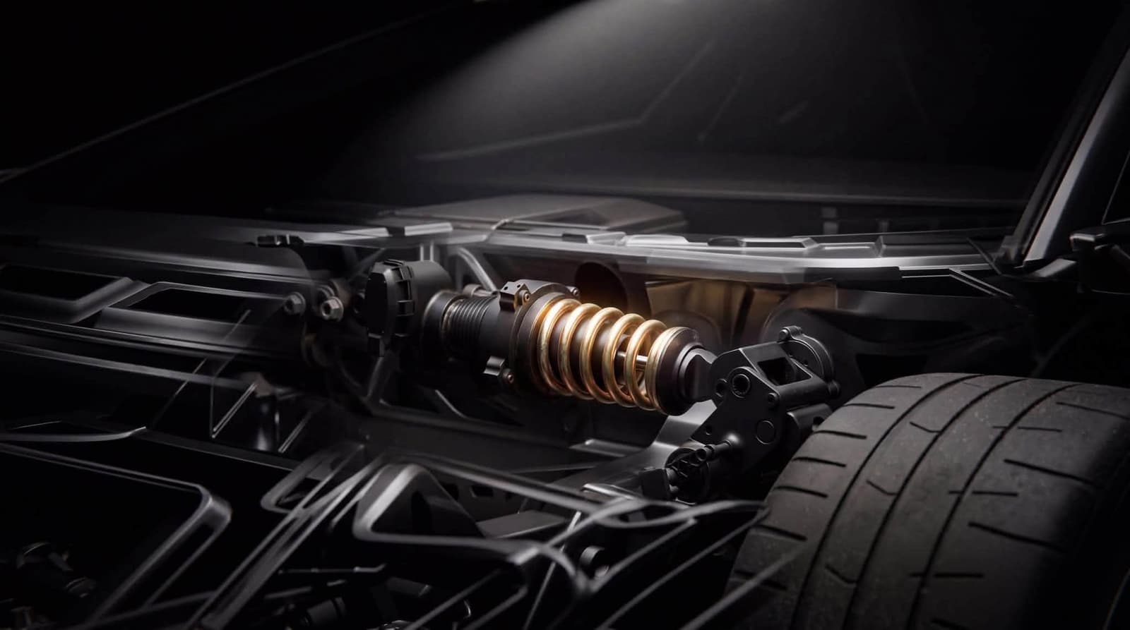 Blick auf das Fahrwerk des Roadsters: ein quer im Rahmen liegender Dämpfer mit goldener Feder, daneben der Reifen