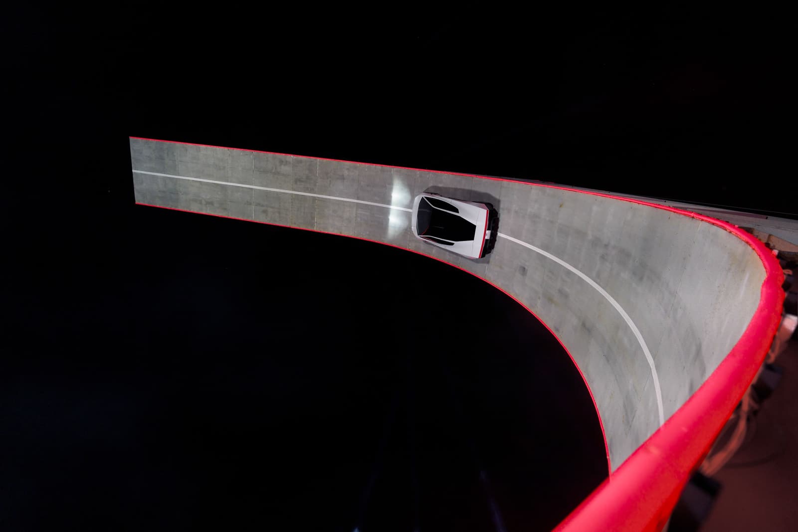 Der Roadster fährt an der Innenwand der gebogenen Rampe entlang