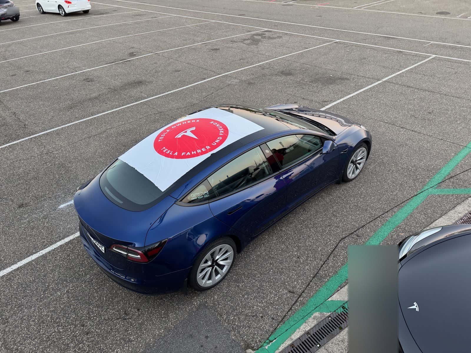 Tesla Model 3 mit TFF-Vereinsflagge auf dem Dach im Fahrerlager
